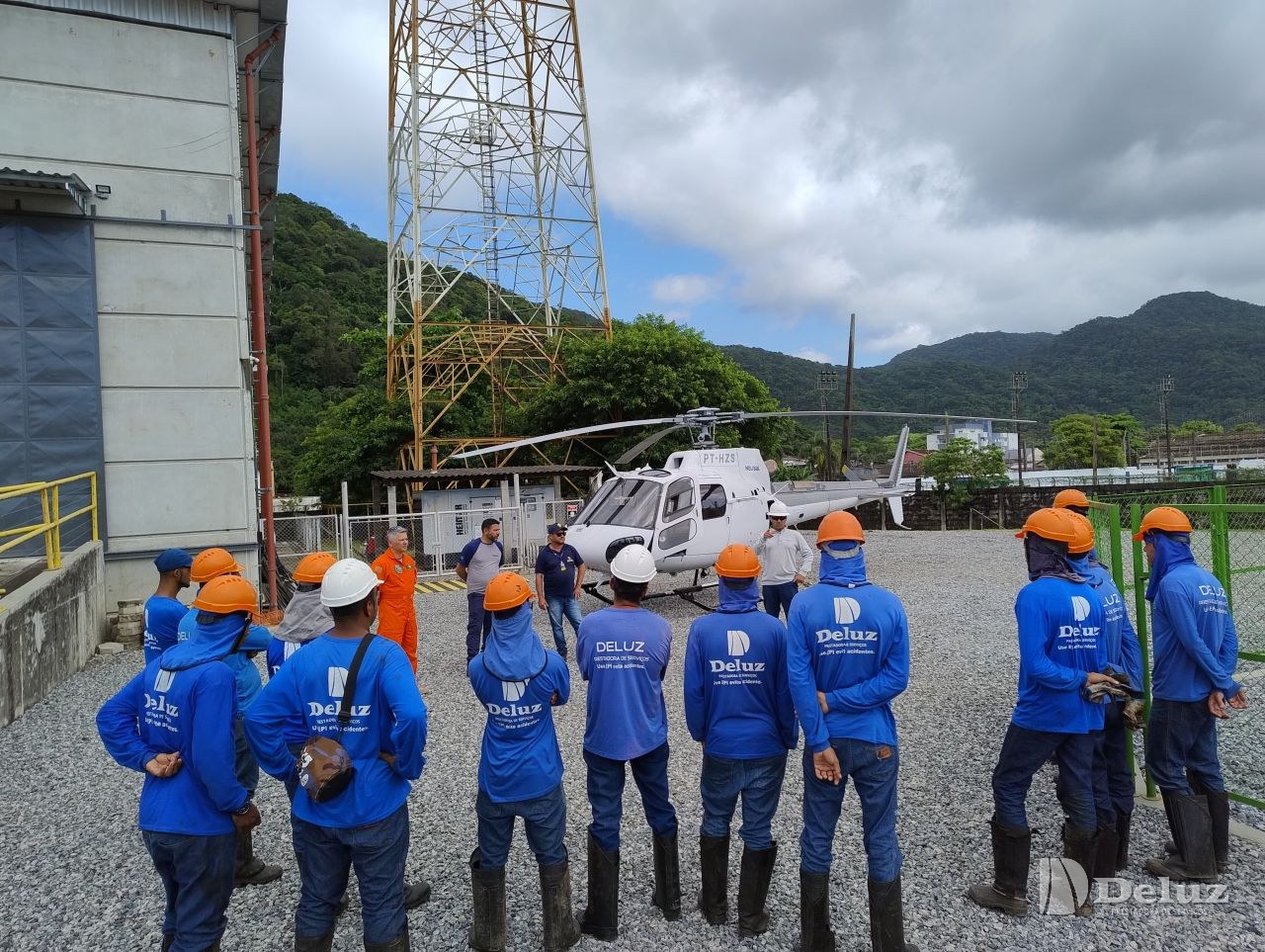 Equipe reunida para a orientação de segurança antes do embarque, na subestação ao pé da serra
