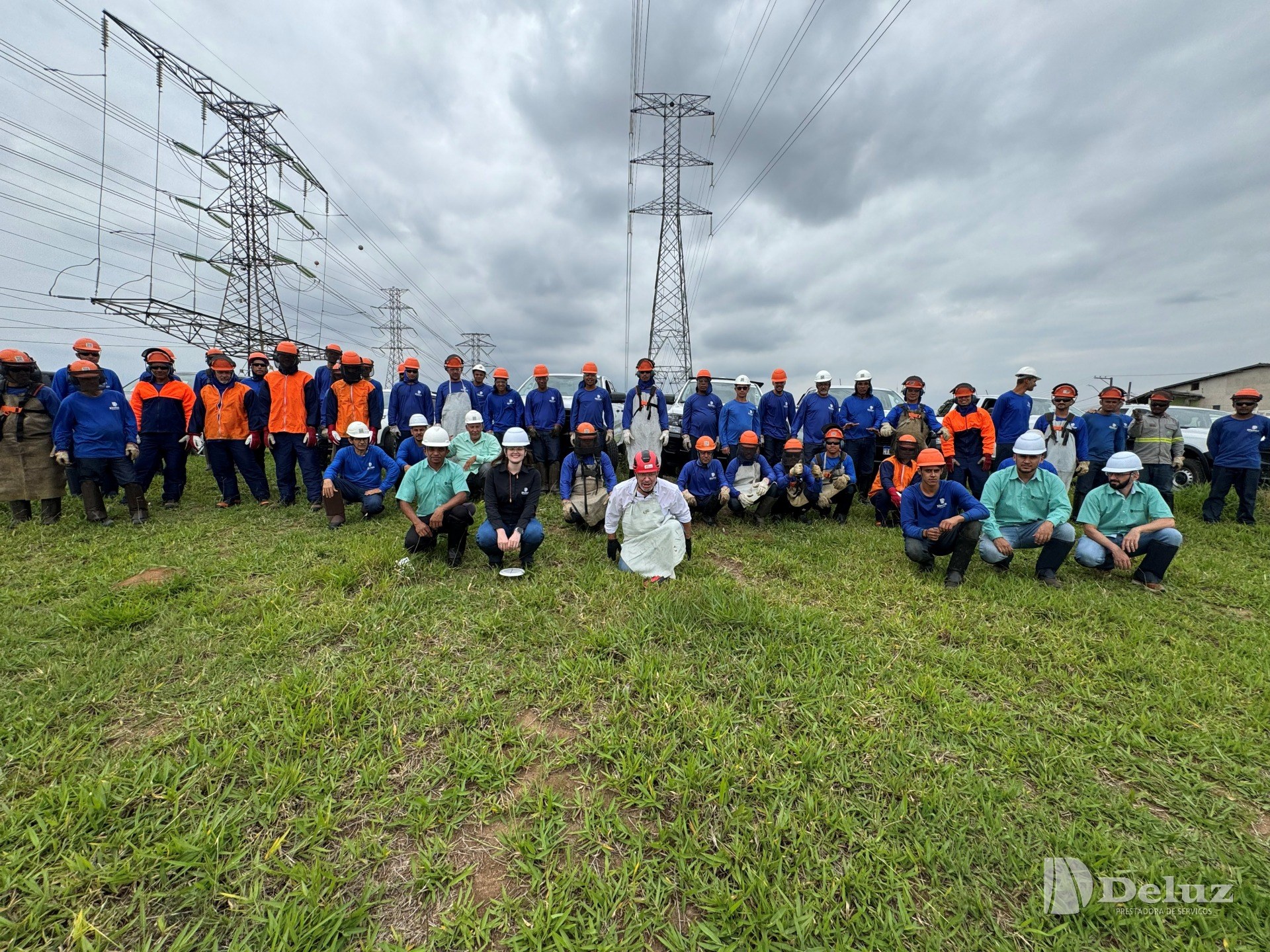 Turma inteira reunida sob as linhas de transmissão, ao pé das torres, ao final do treinamento