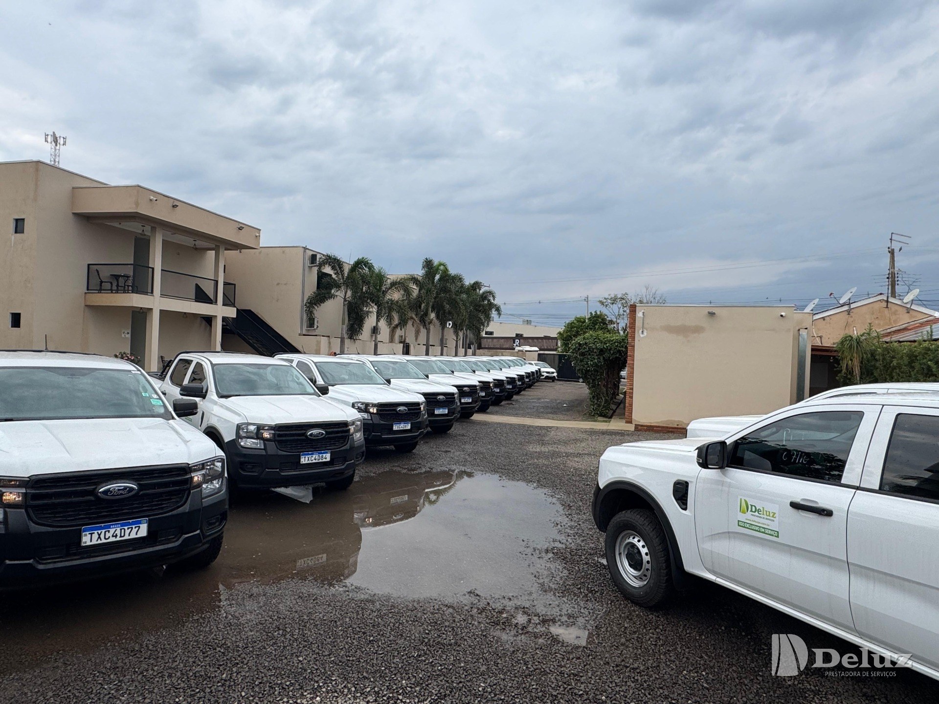 Fila de caminhonetes Ford Ranger brancas novas, estacionadas no pátio da sede